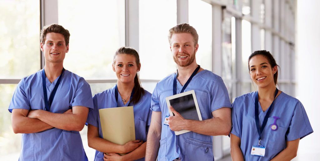 describing open positions at the hospital a group of nurses wearing blue scrubs