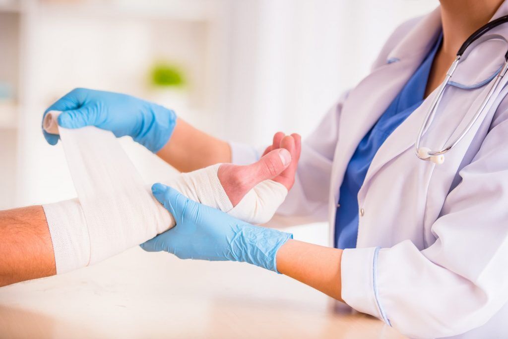 patient getting hand bandage changed as part wound care treatment