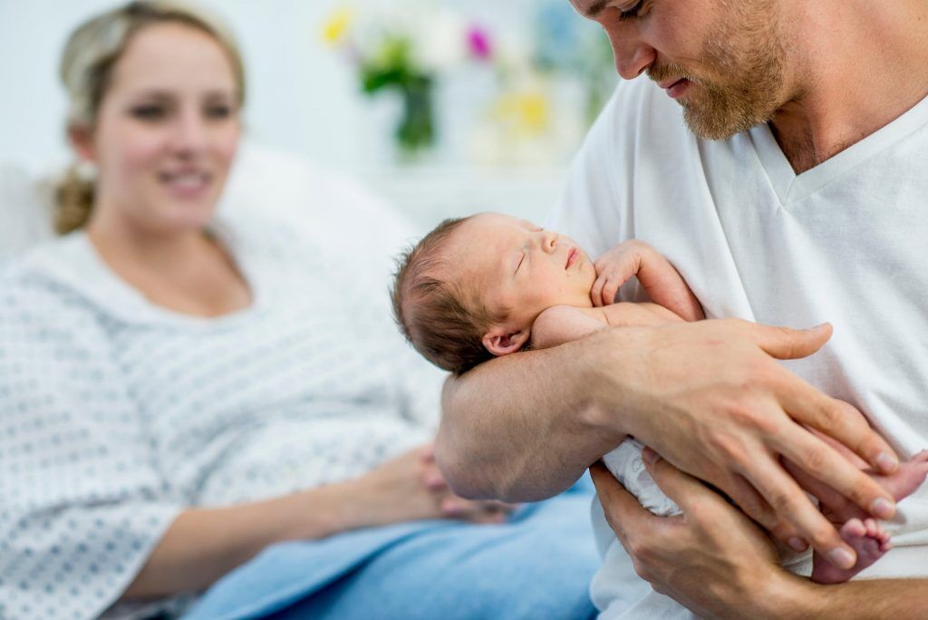 newborn baby with parents in family birthing center